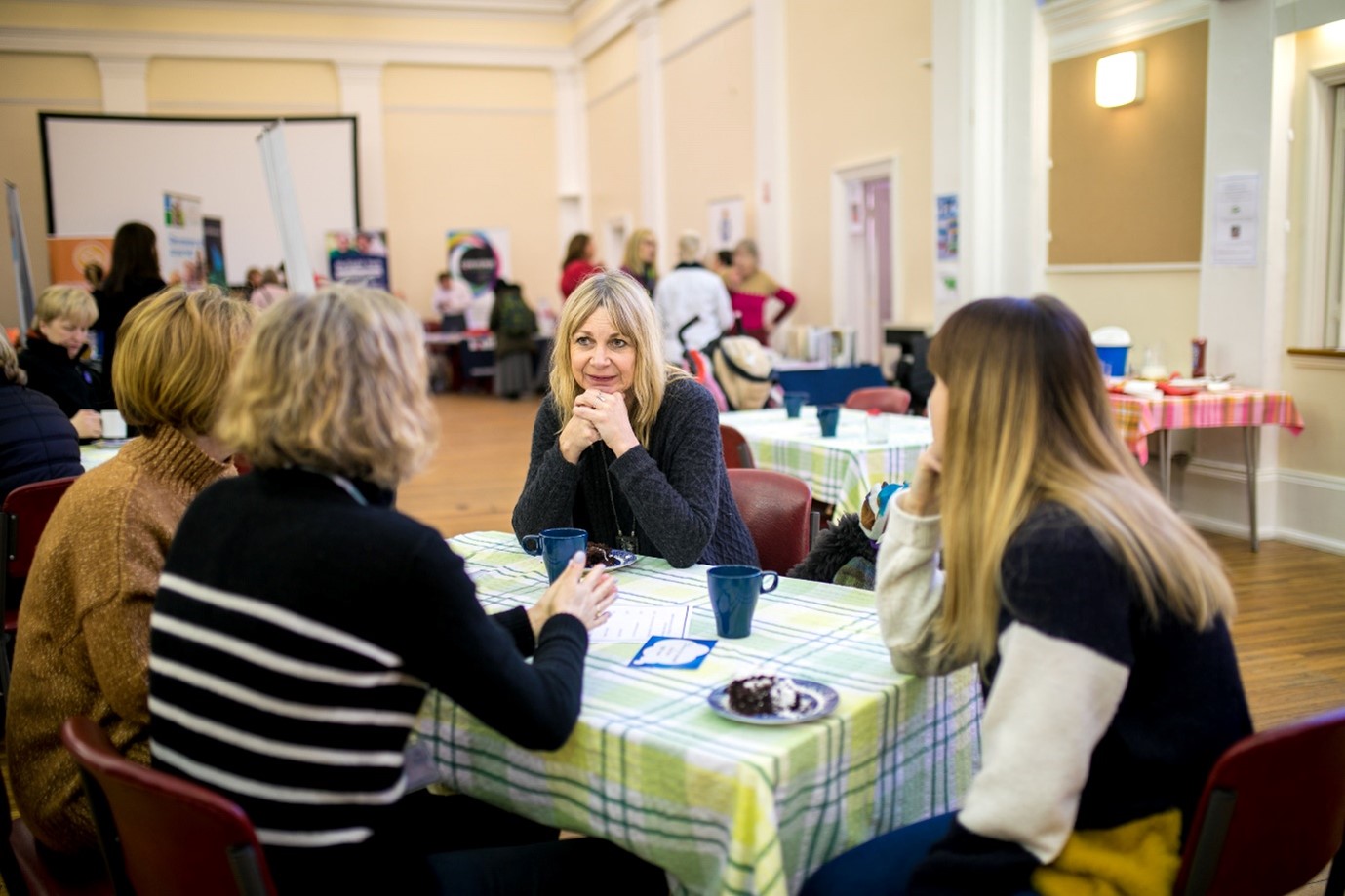 Four women sitting around a table conversing, for “Inside Kyra’s SOFIA Course for Anxiety Support”