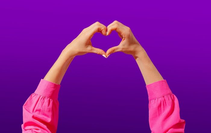 A woman making a love heart symbol with her hands, for “Stand in Your Space: A Unique Group Coaching Journey for Women”