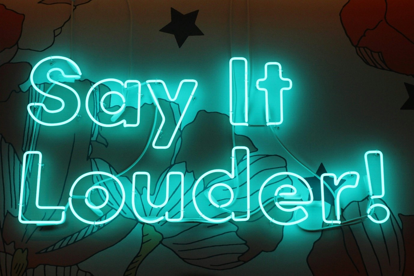 A blue neon sign reading Say It Louder, for “Learning to Say No: Our Boundaries and Self Care Workshop”