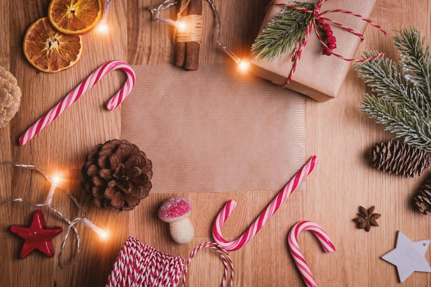 Interior, present wrapping accoutrements litter a wooden table, for “Roses in the Snow: Supporting Young Women’s Wellbeing”